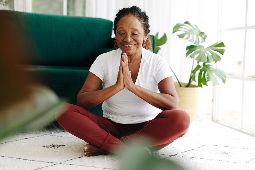 Woman sitting on floor and doing yoga at home
