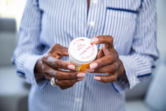 Woman holding medication and looking at label